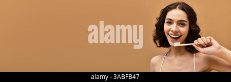 Eine hübsche junge Frau mit Zahnspangen zeigt ihre Zahnarztpraxis, während sie im Studio breit lächelt, Banner Stockfoto