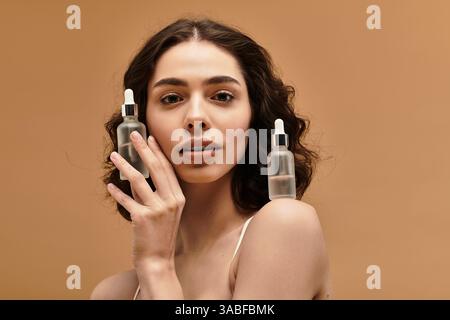 Eine junge Frau mit Zahnspangen zeigt ihre Hautpflegeroutine in einem künstlerischen Atelier. Stockfoto