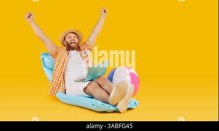 Fröhlicher Mann mit Laptop, feiert den Erfolg im Urlaub Stockfoto