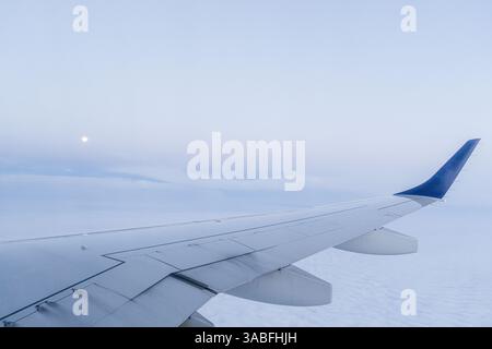 Nahaufnahme eines Flugzeugflügels im Flug an einem bewölkten Tag Stockfoto