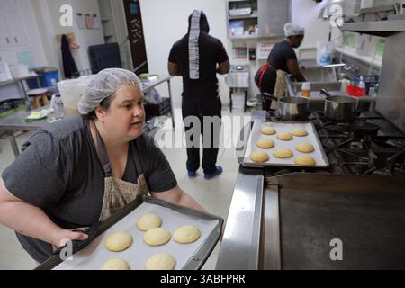 25. April 2018 - St. Louis, MO, USA - Tina Dimitry, 49, aus St. Louis, holt am Mittwoch, 25. März 2018 frisch gebackene Kekse aus dem Ofen in der Laughing Bear Bakery. Die Bäckerei befindet sich in der Küche der Centenary United Methodist Church in der Innenstadt von St. Louis, Mo., und bietet Ex-Tätern einen bezahlten Job und einen Neuanfang. (Foto: © Cristina M. Fletes/TNS via ZUMA Wire) Stockfoto