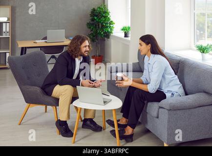 Junge Mann und Frau treffen sich im Büro und reden über geschäftliche Zusammenarbeit Stockfoto