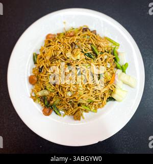 Pfannkuchen mit Gemüse und Gurke auf weißem Teller und schwarzem Hintergrund Stockfoto