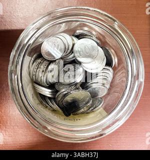 Glas mit Glasspitze von oben mit Rupiah-Münzen Stockfoto