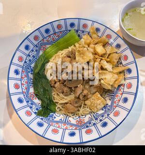 Bakmie , eine Schüssel Nudeln mit Huhn und Pilzen serviert mit separater Brühe Stockfoto