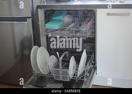 Moderne Küche mit eingebautem, offenem Geschirrspüler mit Geschirr Stockfoto