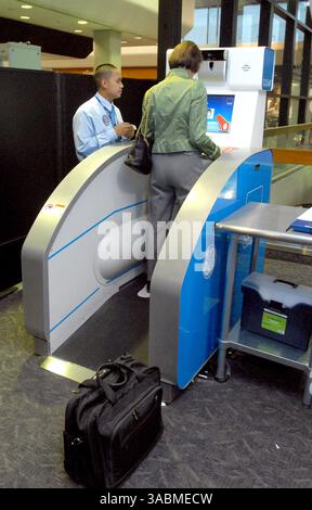 Peggy Hinman aus Atherton benutzt einen Fingerabdruck, um am Mittwoch, den 10. Oktober 2007, bei der Sicherheitskontrolle am Flughafen San Francisco einzuchecken. Der klare Mitarbeiter von Blaquera überwacht den Prozess. Hinmans Fingerabdruck wurde zum ersten Mal auf dem Scanner nicht richtig gelesen, also benutzte sie einen Netzhautscan, um die Sicherheit zu löschen. Die private Sicherheitskontrolle hat viel kürzere Zeiten an den Sicherheitskontrollen am Flughafen. Kunden liefern Fingerabdrücke und Retina Scans und zahlen dann 9 pro Jahr, um lange Schlangen zu umgehen. (Bob Pepping/Contra Costa Times/ZUMA Press) Stockfoto
