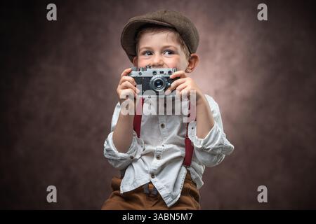 Junge Fotografin mit Retro-Kamera, die Bilder vor Vintage-Hintergrund macht Stockfoto