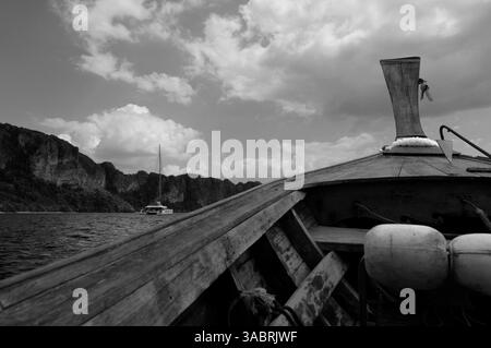 Fahren Sie durch Krabi Gewässer, das Langboot trifft auf einen entfernten Katamaran in Schwarzweiß Stockfoto