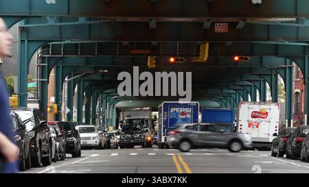 New York City, USA - 31. August 2023: Pepsi Truck, erhöhte U-Bahn über der Straße. Metropolitan Bridge über die Straße, Queens. Long Island U-Bahn-Linie. Autos unter metallischen Bahngleisen. New York City Life. Stockfoto