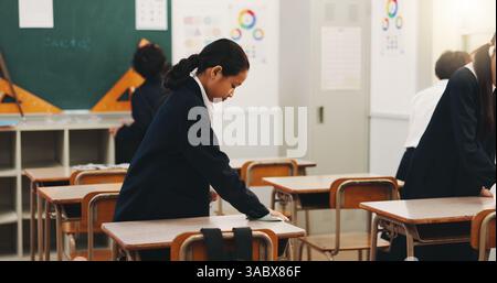 Schüler, Kind und Putztisch in der Schule für Hygiene, Lernverantwortung und Disziplin im Klassenzimmer. Japanische Akademie, Leute und Oberfläche abwischen Stockfoto