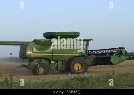 John Deere Mähdrescher, der Weizen zur Erntezeit in Kansas schneidet Stockfoto