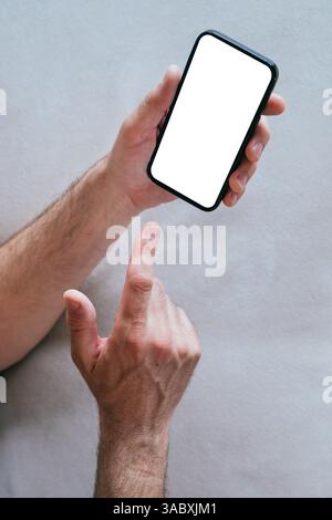 Nahaufnahme männlicher Hände, die das Smartphone halten, mit leerem weißen Mockup-Touchscreen, selektiver Fokus Stockfoto