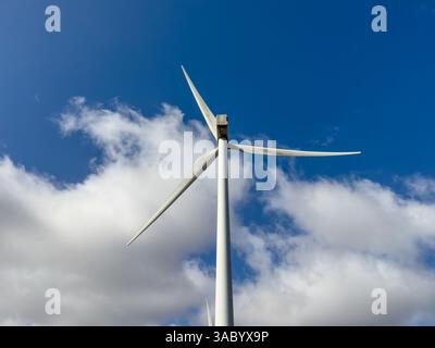 Windkraftanlage an einem sonnigen britischen Tag vor einem blauen bewölkten Himmel. Stockfoto