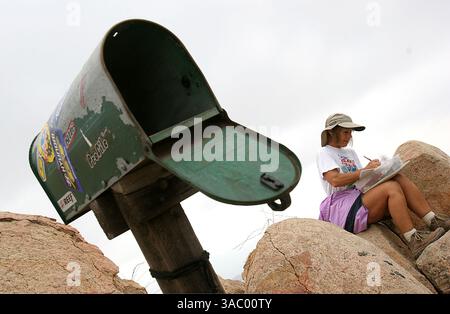 (Veröffentlicht am 6. November 2005, B-5, N-1) Barbara Janson aus Ramona, KALIFORNIEN, liest und schreibt in einer Zeitschrift auf dem Iron Mountain in Poway. Der Briefkasten enthält Artefakte von Wanderern, die es nach oben schaffen, sowie einen Verbandskasten und Toilettenpapier. UT/John Gastaldo Stockfoto
