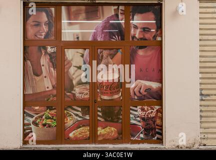 Retro Coca-Cola Werbespot Mann und Frau auf einem Poster. Grunge Retro Vintage Coca-Cola Werbefoto an einer Wand eines Gebäudes in der Altstadt von Durres A Stockfoto