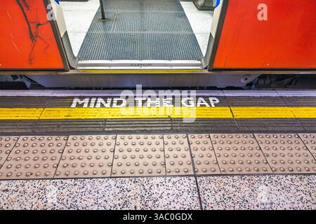 Beachten Sie die Lückenwarnung auf dem Londoner U-Bahnsteig mit offener Tür Stockfoto