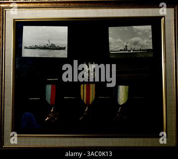 (Veröffentlicht 10.8.2005, NC-4) Casey Kaminski von Oceanside hat Fotos des Zerstörers Kujaviak gesammelt, der 1942 links auf eine Landmine traf, und eines Kreuzers namens Dragon, Kaminski hat auch drei britische Medaillen von links: Star of the Atlantic, Star of Africa und Star of France. Laura Embry/Union-Tribune Stockfoto