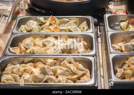 Chinesische Pfannenknödel mit verschiedenen Füllungen auf dem Brick Lane Market in London Stockfoto