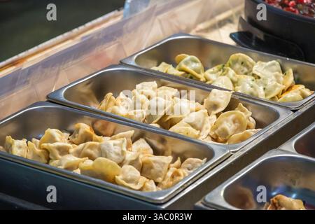 Chinesische Pfannenknödel mit verschiedenen Füllungen auf dem Brick Lane Market in London Stockfoto