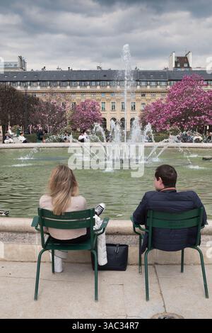 Paare genießen den Brunnen im Jardin du Palais Royal in Paris im Frühjahr. Stockfoto
