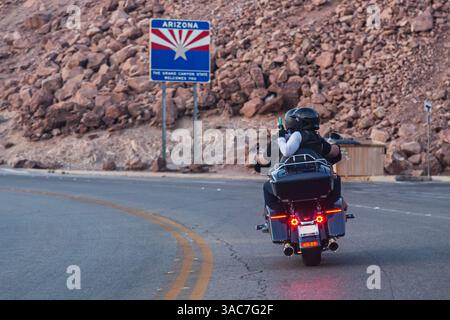 Radfahrer, Mann und Frau, fahren mit dem Motorrad auf der Bergstraße und machen Fotos von Sehenswürdigkeiten unterwegs. Zwei Motorradfahrer fahren auf dem kurvenreichen Highway mit maßgeschneidertem Hubschrauber. Rückansicht, Nahaufnahme. Hoover Dam, Nevada Stockfoto