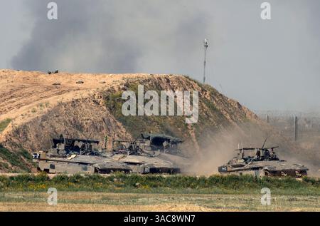 Süd-Israel, Israel. April 2025. Die israelischen Armeegepanzerten Personals-Träger (APCs) ziehen vom südlichen Gazastreifen nach Süd-Israel und parken hinter einem Berm, während der Rauch aus dem Gazastreifen aus den Kämpfen am 3. April 2025 steigt. Israel hat die Kämpfe im südlichen Gazastreifen verstärkt, da sie die Sicherheitszonen im Gazastreifen vergrößern, um den Druck auf die Hamas zu erhöhen, die seit dem 7. Oktober 2023 inhaftierten israelischen Geiseln freizulassen. Foto von Jim Hollander/UPI Credit: UPI/Alamy Live News Stockfoto