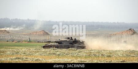 Süd-Israel, Israel. April 2025. Ein israelischer Armeepanzer wirft Staub auf, während er sich im Süden Israels bewegt und am 3. April 2025 in ein vorderes Einsatzgebiet in der Nähe der Grenze zum südlichen Gazastreifen (hinter ihm) zurückkehrt. Israel hat die Kämpfe im südlichen Gazastreifen verstärkt, da sie die Sicherheitszonen im Gazastreifen vergrößern, um den Druck auf die Hamas zu erhöhen, die seit dem 7. Oktober 2023 inhaftierten israelischen Geiseln freizulassen. Foto von Jim Hollander/UPI Credit: UPI/Alamy Live News Stockfoto