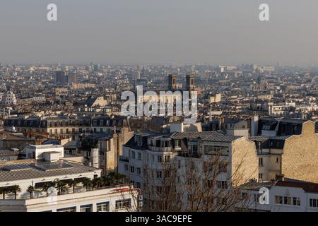 Blick aus der Vogelperspektive auf Paris, mit einer weitläufigen Stadtlandschaft mit historischen Gebäuden und architektonischen Wahrzeichen unter einem trüben blauen Himmel. Stockfoto