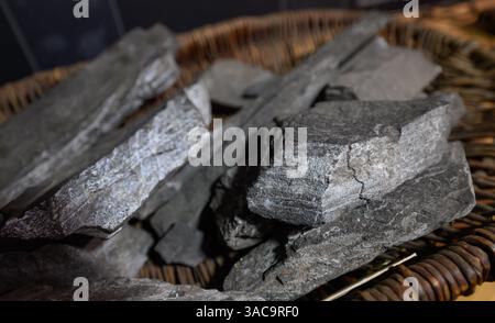 PRODUKTION - 02. April 2025, Sachsen-Anhalt, Sangerhausen: Kupferschiefer liegt in einem historischen Korb in der Ausstellung im Erlebniszentrum Bergbau Röhrigschacht Wettelrode. Die ersten Bergleute begannen vor 825 Jahren in der Region Mansfeld mit dem Graben nach Kupfererz. Ab 1750 wurde ein intensiver Bergbau durchgeführt. Insgesamt wurden rund 2,6 Millionen Tonnen Kupfer und 14.213 Tonnen Silber aus dem Erz in der Region gewonnen. Bis Dezember werden insgesamt 38 Veranstaltungen an den Beginn der Bergbau- und Hüttenwirtschaft in der Region Mansfeld erinnern. Als bedeutender Kupfer- und Silberproduzent trug die Region dazu bei Stockfoto