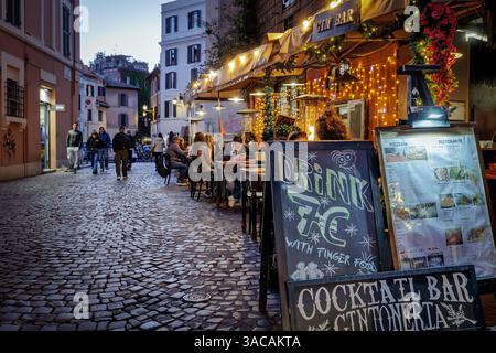 Rom, Italien - 31. März 2025: Abends in Trastevere, einem typischen Trattoria-Restaurant, das von Touristen in der Stadt besucht wird, mit Tischen und Stockfoto