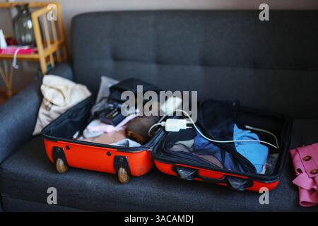Offener Koffer mit Kleidung und persönlichen Sachen für unterwegs verpackt Stockfoto