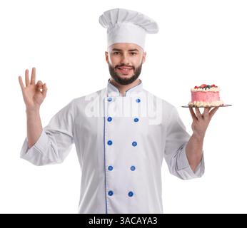Glücklicher Konditor in Uniform, der leckeren Kuchen mit Beeren hält und eine gute Geste auf weißem Hintergrund zeigt Stockfoto