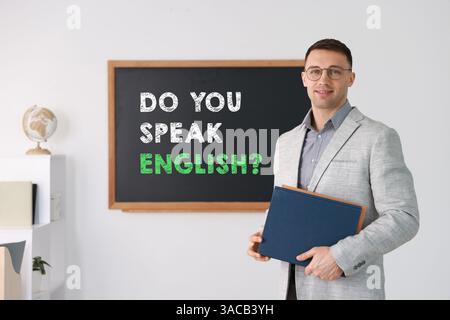 Lehrer in der Nähe der schwarzen Tafel mit Phrase sprichst du Englisch? Im Klassenzimmer Stockfoto