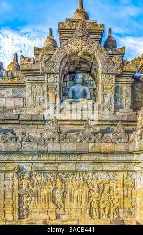 Java, Indonesien. Nahaufnahme einer der ursprünglichen 504 Statuen Buddhas in einer geschnitzten Nische des Borobudur-Tempels. Stockfoto