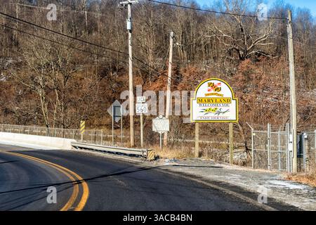 Oakland, USA - 20. November 2022: Grenze zu West Virginia mit Straße im Winter Schnee und Willkommensschild für Maryland State und Slogan für viel Spaß Stockfoto