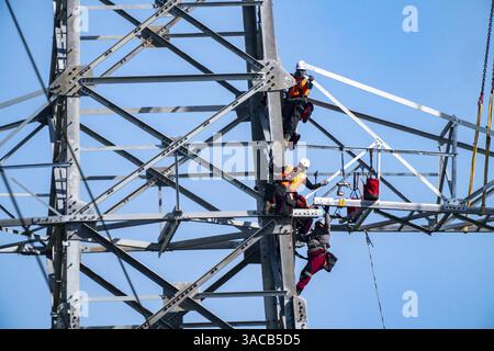 Monteure, die einen Stahlgitterturm als Teil einer 380-kV-Hochspannungsleitung zwischen Wesel und Düsseldorf errichten, um die Übertragungskapazität in zu erhöhen Stockfoto