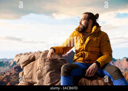 Der Wanderer stellt sich der Herausforderung, durch die Wildnis zu wandern, und genießt die Panorama-Berglandschaft als Erinnerung an Kraft und die Belohnung von Outdoor-Abenteuern. Abenteuerlustige. Stockfoto