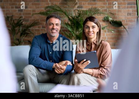 Geschäftsteam verschiedene Personen, die bei einem Meeting auf einem Sofa im Büro sprechen. Stockfoto