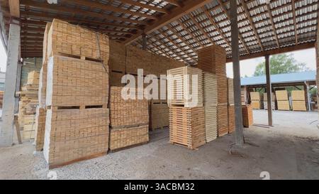 Lagerung von Holzdielen und -Brettern im Lagergebäude unter dem Dach Stockfoto