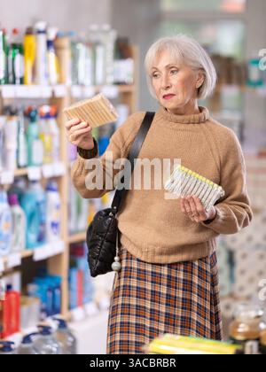 Eine Frau, die sich im Laden eine Wäschespanne ausgesucht hat Stockfoto