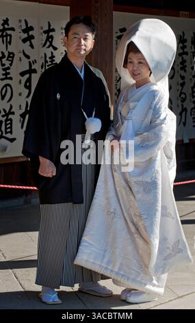 Eine Braut und ein Bräutigam, gekleidet in einem traditionellen japanischen Hochzeitskimono, nehmen an einer formellen Shinto-Hochzeitszeremonie im Meiji Jingu-Schrein in Tokio Teil. Stockfoto