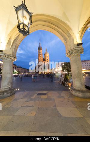 Krakauer Hauptplatz und Mariacki-Kathedrale von den Bögen der Markthalle aus gesehen. Stockfoto