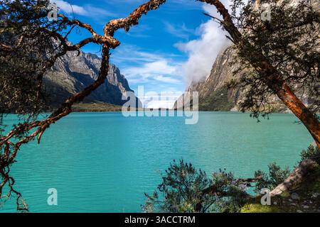 Ein atemberaubender türkisfarbener See reflektiert den blauen Himmel, eingebettet zwischen hoch aufragenden Bergen. Die friedliche Landschaft ist Teil der berühmten Laguna 69 Trek in Hu Stockfoto