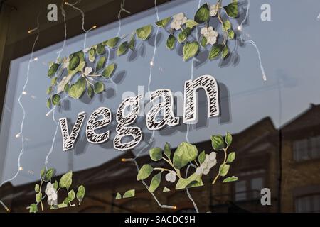 Vegane Schaufenster mit grünem Design und Lichterketten im Ladenbereich der Stadt Stockfoto