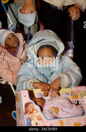 11. Dezember 2004 - Cincinnati, Ohio, USA - die zweijährige Kaya Smith von OTR, schnappt ein neues Puppengeschenk von Santa's Elves, die am Programm Luminaria, Harmony of Light im Washington Park teilnahmen, das 2000 von Thomas Courtney nach den Cincinnati-Unruhen gegründet wurde. (Bild: © Ken Stewart/ZUMA Press) Stockfoto