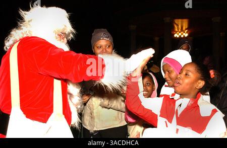11. Dezember 2004 – Cincinnati, Ohio, USA – der Weihnachtsmann erhält von einem der vielen Kinder, die am Programm Luminaria, Harmony of Light im Washington Park teilnahmen, das 2000 von Thomas Courtney nach den Cincinnati-Unruhen für die Bewohner des Rheins gegründet wurde. (Bild: © Ken Stewart/ZUMA Press) Stockfoto