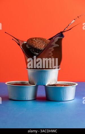 Schokoladenkuchen in geschmolzenen Becher mit Spritzer – lebendige Farbdessert Action Shot Stockfoto