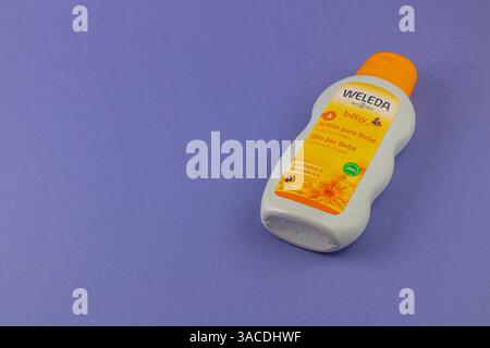 24.03.25 Lviv UkraineA Babyölflasche sitzt auf einem leuchtend violetten Hintergrund. Die orangefarbene Kappe ergänzt das Etikett und zeigt seine natürlichen Zutaten A Stockfoto