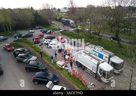 Clapgate Lane, Birmingham, 4. April 2025: Die Bewohner haben sich so weit das Auge reicht, um ihren Müll am Freitagmorgen an einer vorübergehenden Müllsammelstelle abzugeben. Die Fahrzeuge waren Stoßfänger an Stoßfänger entlang der Clapgate Lane, die bis zum Woodgate Valley Country Park, einem Naturschutzgebiet, führten, wo sie ihre Müllsäcke in einen Müllwagen kippten. Die Szenen waren besser organisiert als in den vergangenen Tagen, obwohl der Verkehr viele Menschen um eine Stunde auf Reisen brachte. Der Stadtrat von Birmingham hat die Stadt in einen großen Vorfall versetzt, um den Rückstand der Abfälle zu beseitigen, nachdem Müllarbeiter dies getan haben Stockfoto